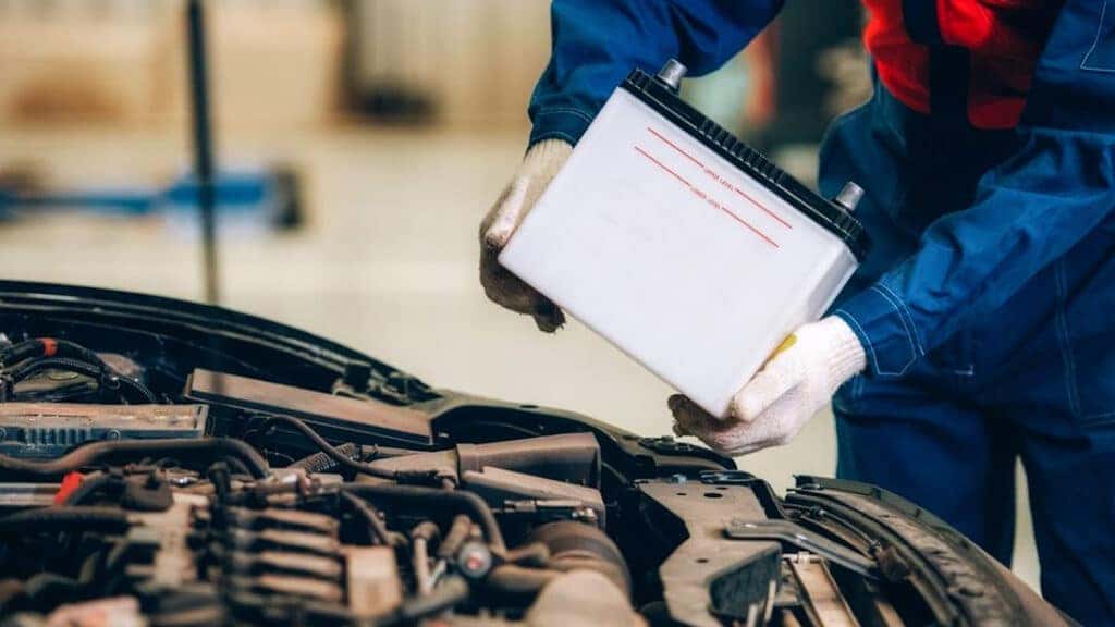 A technician installing a new vehicle battery.